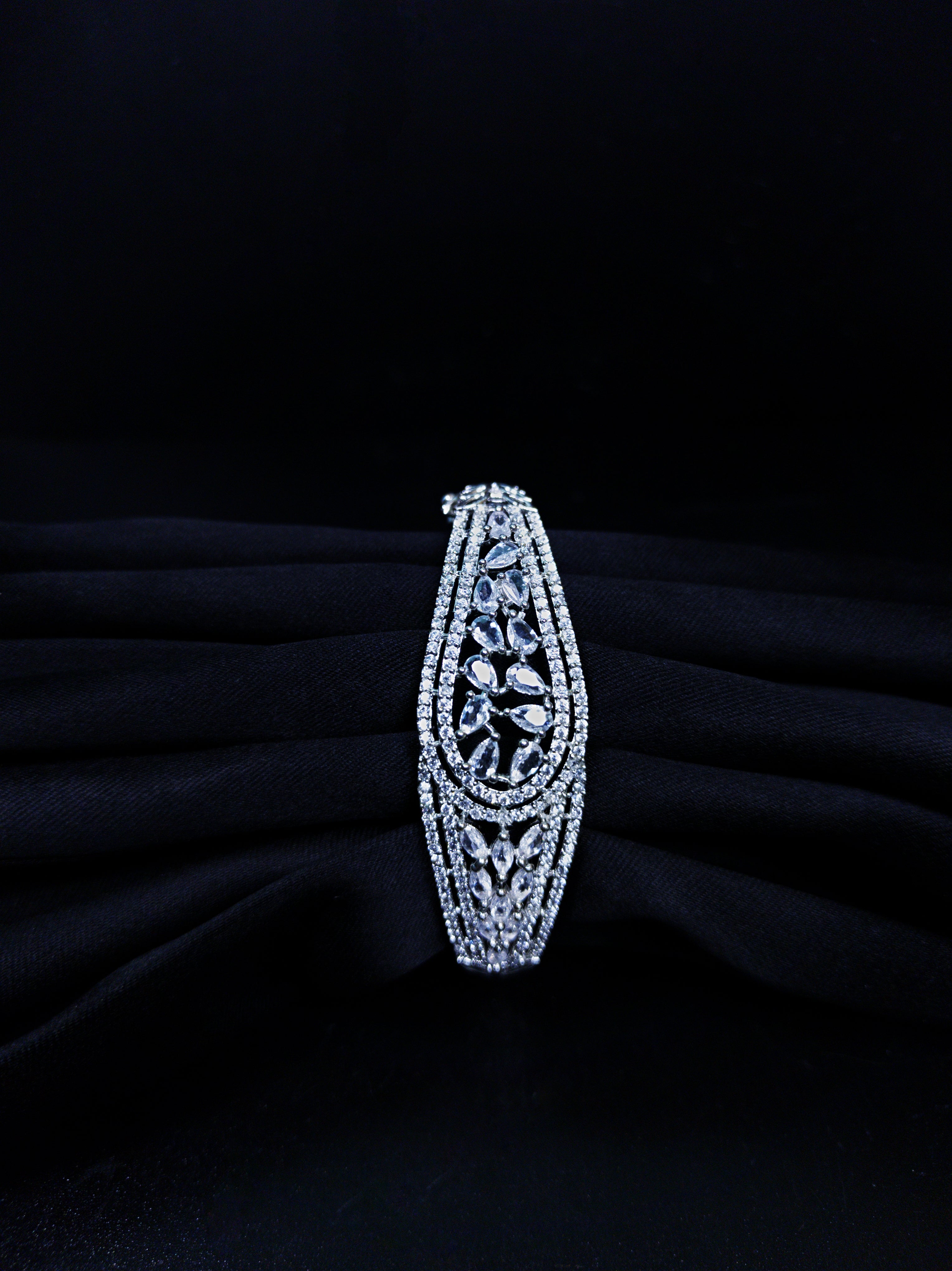 Silver bracelet with intricate design on a black background